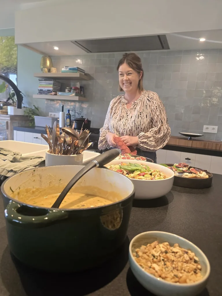 Kristel in haar keuken naast een pot soep